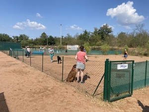 Adhérente et son chien près du portillon du terrain d'éducation